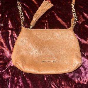 Micheal Kors Crossbody Purse with Gold Hardware ans an oversized tassel
